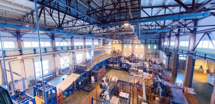 Factory workshop interior and machines on glass production background