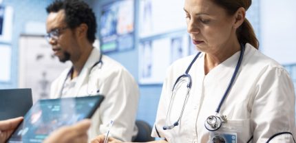Group of diverse doctors in a treatment center reviewing brain scan results, examining neurology mri tests. Experts collaborate on diagnostics, treatment plans and disease prevention. Tomography