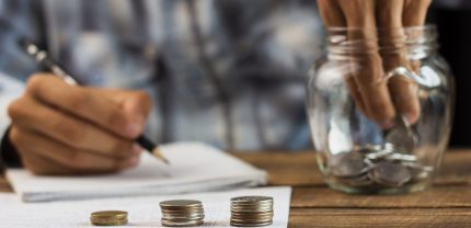 man-taking-out-coins-from-saving-jar