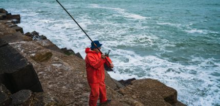 Portrait of an old man fishing in the sea. Fishing concept.