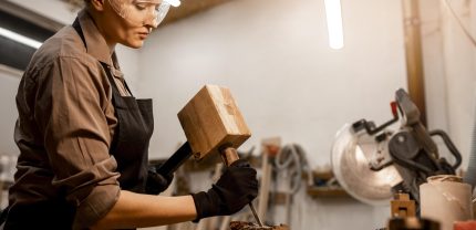 side-view-female-carpenter-sculpting-wood-studio